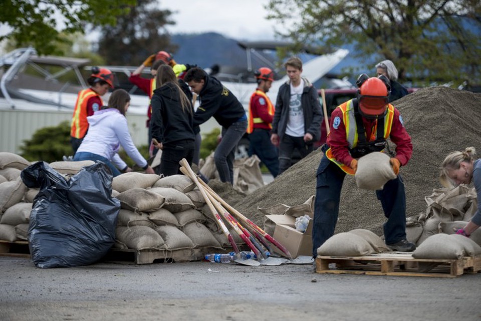 Emergency response workers pile sandbags for critical infrastructure protection.