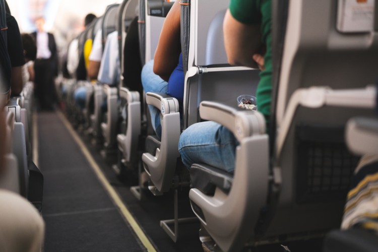 Rows of passengers seated aboard an airplane.